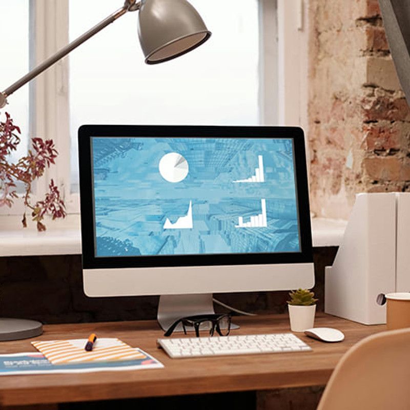 Desktop computer showing sales charts in a bright office